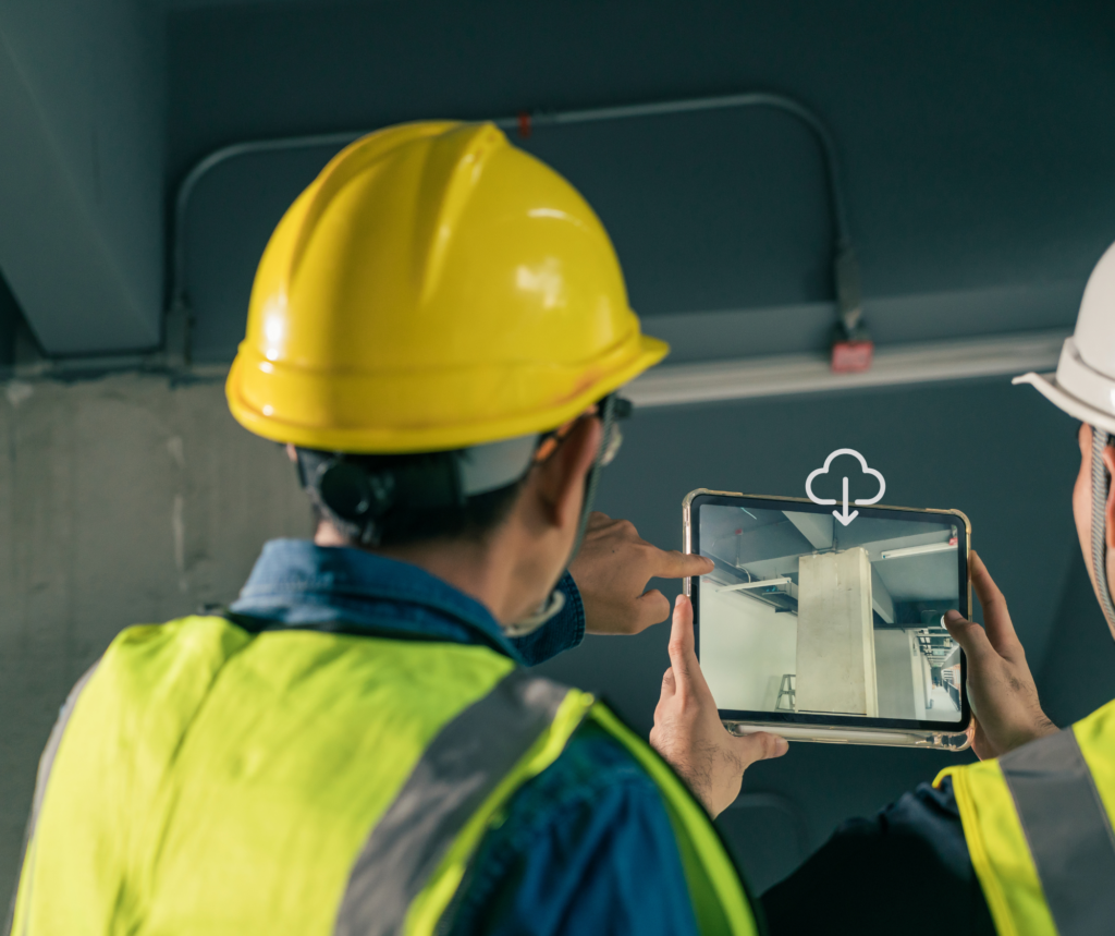 Two construction managers with backs to the camera looking at tablet screen with cloud storage icon