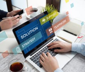 two hands on laptop keyboard with "solution strategy" on screen with blue background